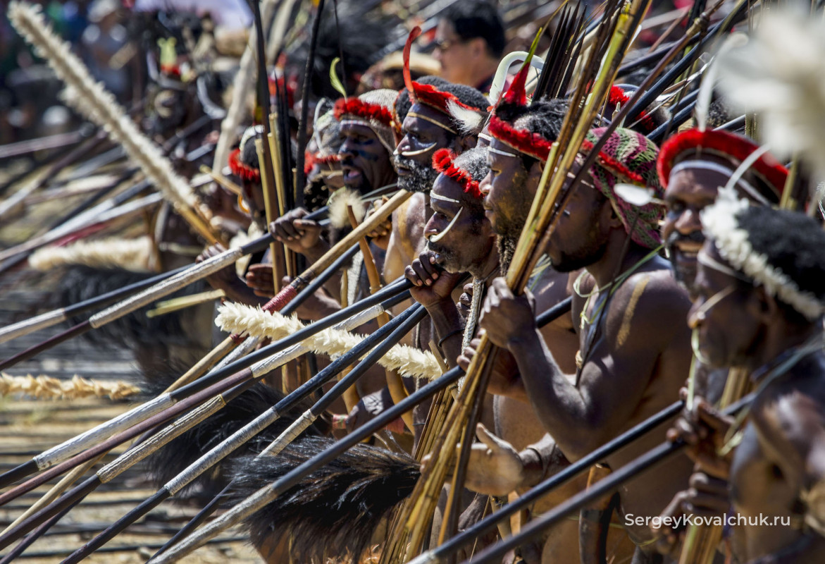 Мужчины разыгрывают сцены сражений в папуасской деревне