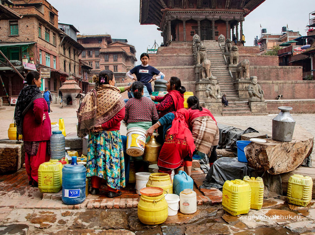 Женщины набирают воду из колодца